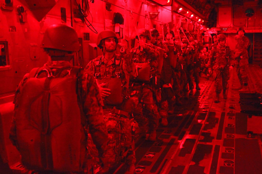 Paratroopers hook their universal static lines inside an Air Force C-17 Globemaster aircraft before participating in a mass tactical airborne jump during Operation Anvil refresher training at North Air Force Auxiliary Base, S.C., Jan. 26, 2017. Army photo by Spc. Christopher Martin