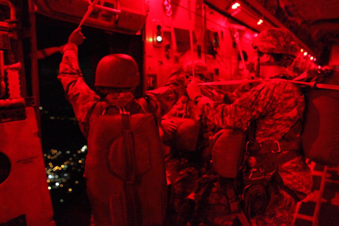 Army Maj. Sterling Morris gathers universal static lines as paratroopers get ready to make a mass tactical airborne jump during Operation Anvil refresher training at North Air Force Auxiliary Base, S.C., Jan. 26, 2017. Morris is assigned to the 412th Civil Affairs Battalion, 360th Civil Affairs Brigade. Army photo by Spc. Christopher Martin