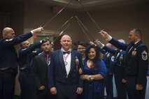 Senior Master Sgt. Michael Reed, 23d Equipment Maintenance Squadron production section superintendent, and his family walk through the ceremonial saber detail, signifying his transition to the rank of chief master sergeant, at the Chief Induction Ceremony, Jan. 28, 2017, at Moody Air Force Base, Ga. The induction ceremony is a time-honored tradition that recognizes Airmen as they make the transition from senior master sergeant to chief master sergeant. (U.S. Air Force photo by Andrea Jenkins/Released)