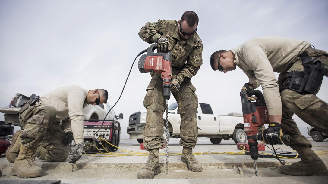 Air Force Tech. Sgt. Miguel Castano, Senior Airman Adam Parizo and Airman 1st Class Abram Burkhart repair the runway at Bagram Airfield, Afghanistan, Feb. 1, 2017. Castano is the 455th Expeditionary Civil Engineer Squadron structures shop noncommissioned officer in charge, Parizo is the squadron's power production specialist and Burkhart is the squadron's structures specialist. The concrete suffered wear and tear from the constant aircraft traffic. Air Force photo by Staff Sgt. Katherine Spessa