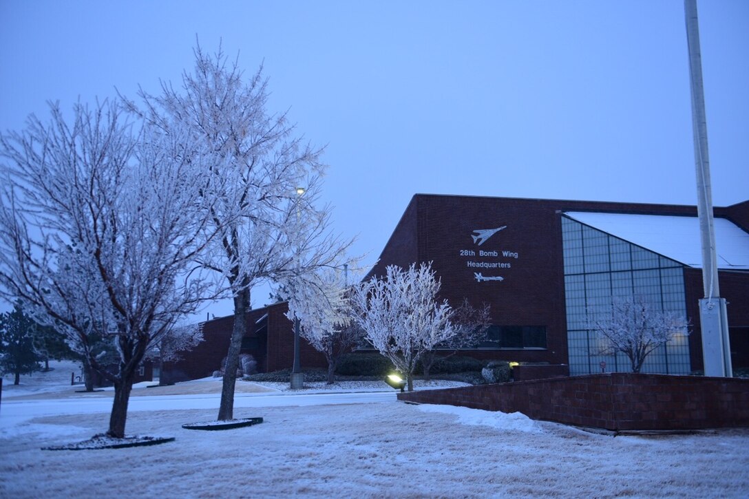 Winter snowfall covers the ground in front of the 28th Bomb Wing headquarters building at Ellsworth Air Force Base, S.D., Jan. 24, 2017. During the winter season remember to use safety when keeping warm inside. (U.S. Air Force photo by Airman 1st Class James L. Miller)
