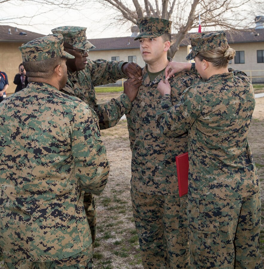 Cpl. Luis Gomez, a military policeman assigned to the MCLB Barstow Command Inspector General's Office, is pinned by MSgt. Donald Lumpkins, command inspector chief, and Sgt Monica Hilpisch, stableman with the Marine Corps Mounted Color Guard, upon being meritoriously promoted to sergeant, Feb 2. This is the Long Beach, Calif. native's secon meritorious promotion in the last 18 months.