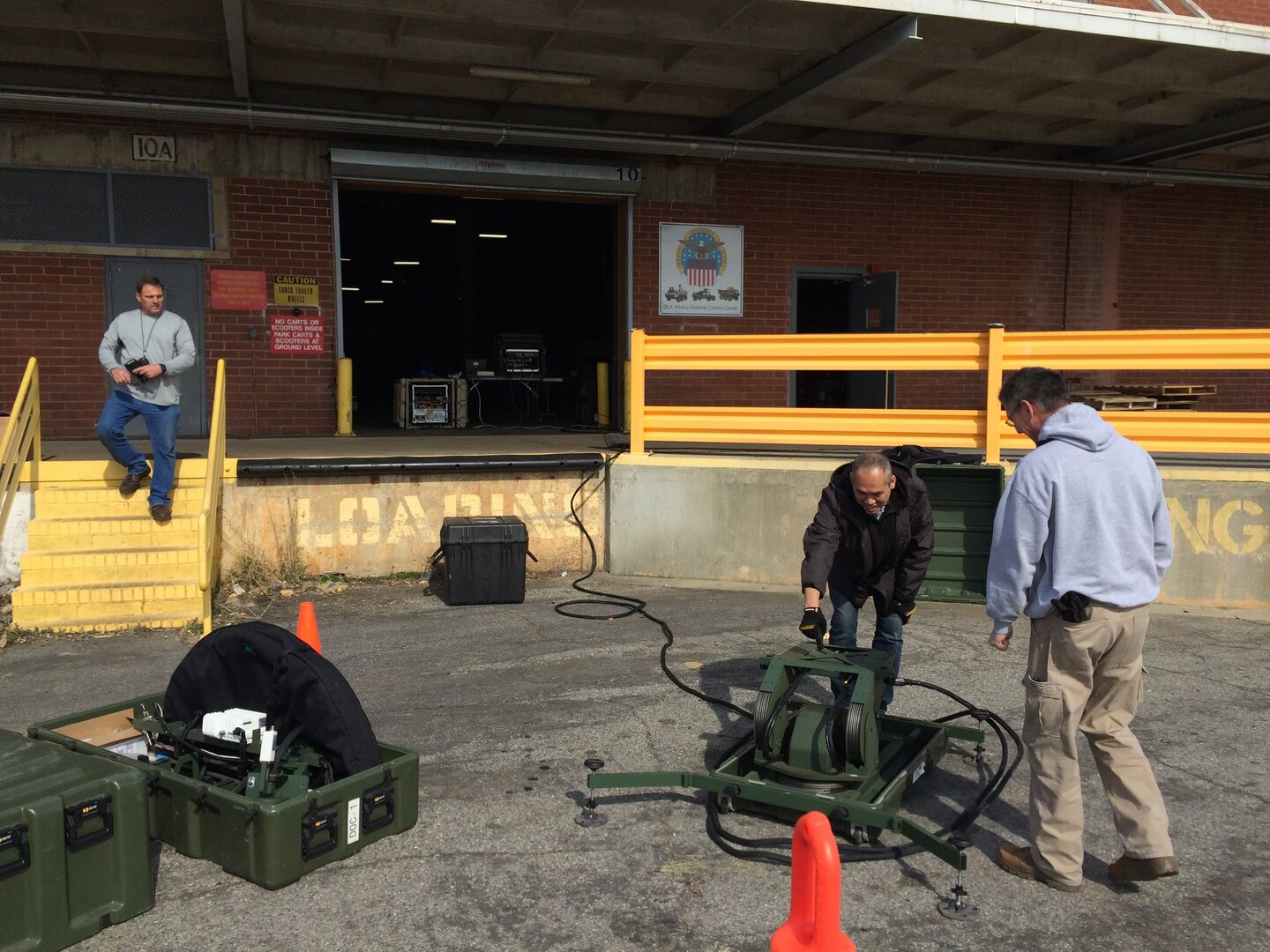 Left to right: DLA Distribution Expeditionary J6 team members Tony Johnson, Paul Chamnan, and John Wolk set up a satellite antenna outside building 1331 to provide network and DSS services in response to the EF3 hurricane that touched down at DLA Distribution Albany on Jan. 22. 