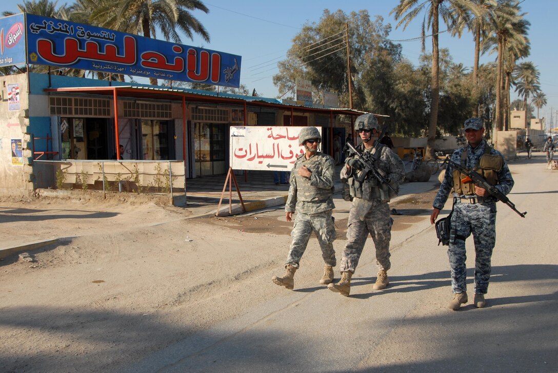 Army 1st Lt. James Gutlielmi of 4th Infantry Division’s 1st Squadron, 10th Cavalry Regiment, 2nd Brigade Combat Team, along with an interpreter and an Iraqi police officer, conducts a joint patrol in Mahawil, Iraq, Jan. 23, 2009. Photo by Navy Petty Officer 2nd Class James Wagner