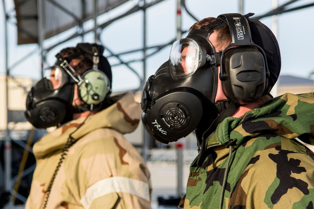 Two Airmen assigned to the 4th Aircraft Maintenance Squadron standby as an F-15E Strike Eagle runs through pre-launch checks during exercise Coronet Warrior 17-01, Jan. 31, 2017, at Seymour Johnson Air Force Base, North Carolina. Airmen performed operations while donning various levels of mission oriented protective posture gear in response to different simulated alarms, threats and chemical or biological agents. (U.S. Air Force photo by Airman Shawna L. Keyes)