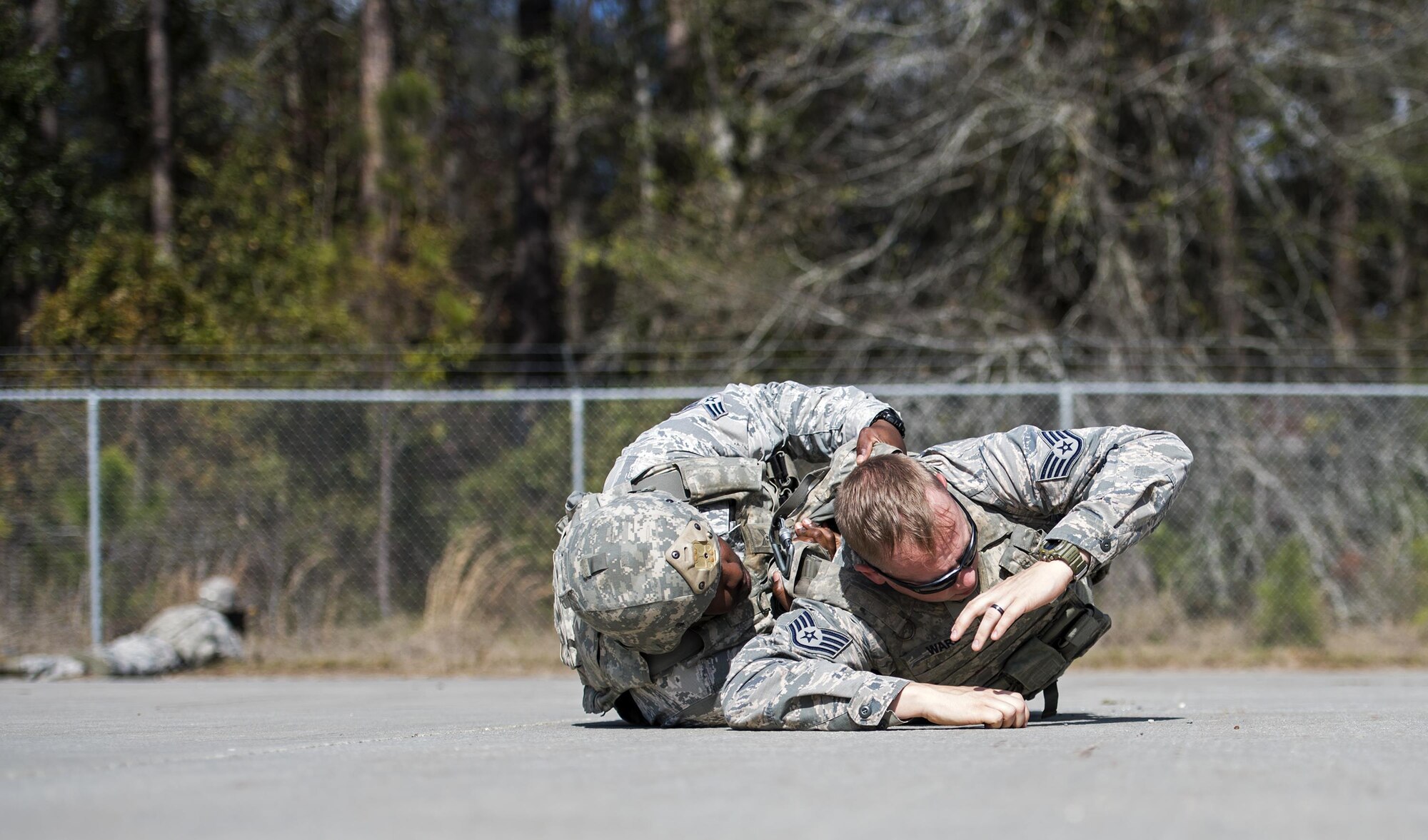 Senior Airman Dennis Fowler, 822d Base Defense Squadron fire team member, checks a simulated casualty for weapons, Feb. 1, 2017, at Moody Air Force Base, Ga. After checking around the casualty, one Airman lifts the body while another ensures no weapons or hazardous materials are hidden underneath. (U.S. Air Force photo by Airman 1st Class Janiqua P. Robinson)