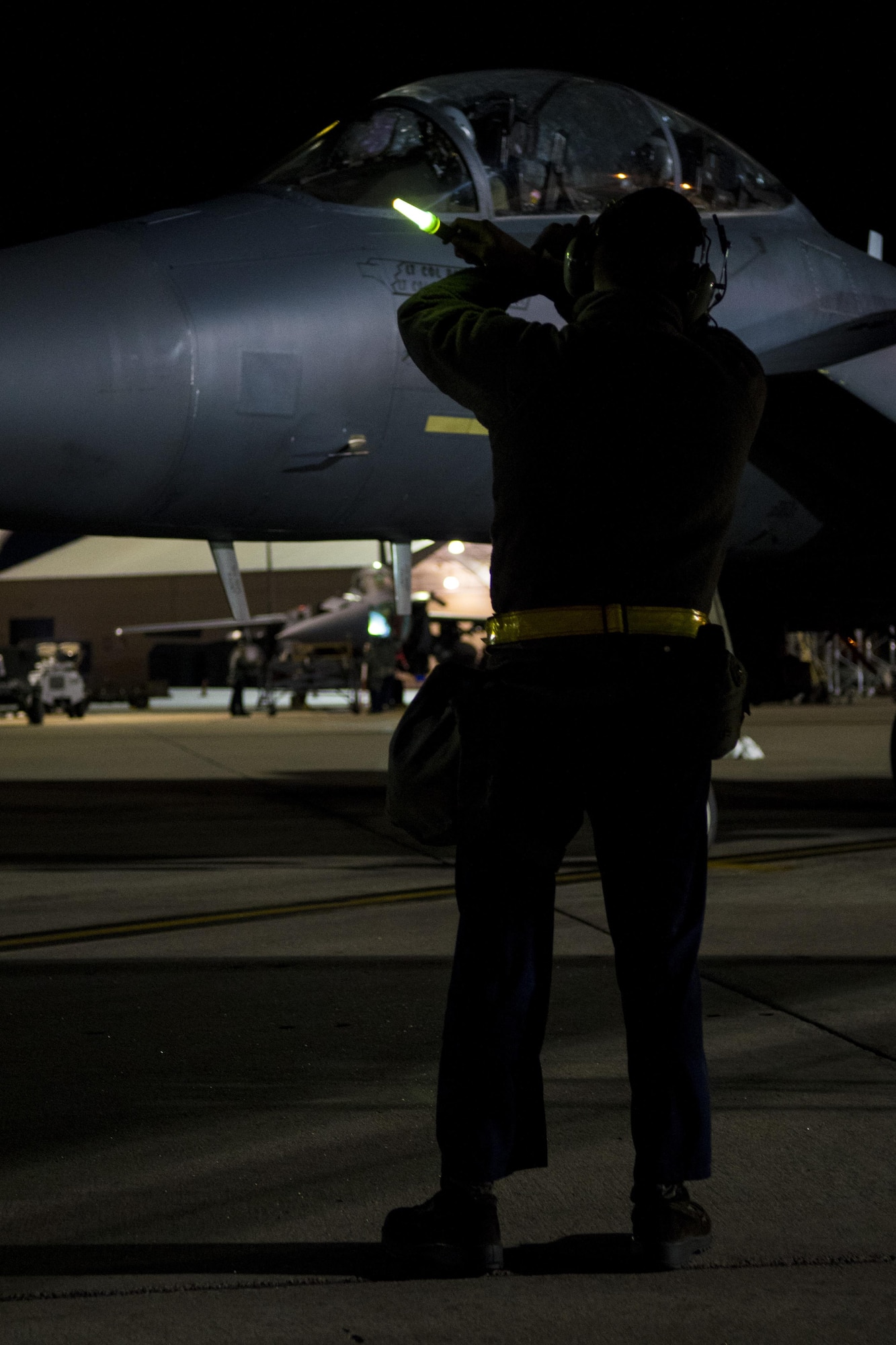 Senior Airman Joshua Sprinkle, 4th Aircraft Maintenance Squadron crew chief, prepares to marshal an F-15E Strike Eagle during exercise Coronet Warrior 17-01, Jan. 31, 2017, at Seymour Johnson Air Force Base, North Carolina. Airmen assigned to the 4th AMXS performed 24-hour operations during the duration of the exercise. (U.S. Air Force photo by Airman Shawna L. Keyes)