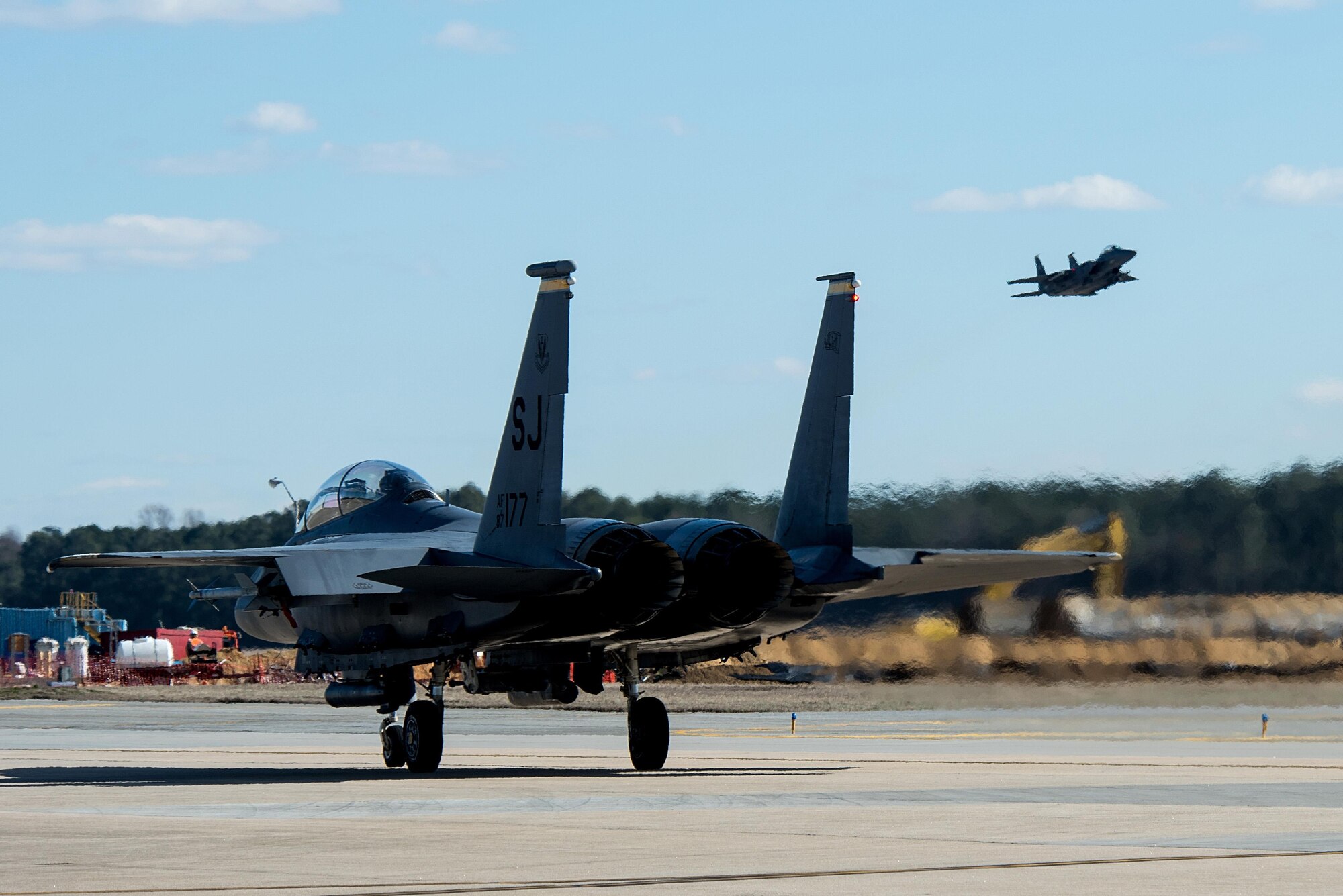 An F-15E Strike Eagle from the 336th Fighter Squadron taxies down the runway while another aircraft takes off during exercise Coronet Warrior 17-01, Jan. 30, 2017, at Seymour Johnson Air Force Base, North Carolina. The exercise is designed to test the 4th Fighter Wing’s ability to operate in an overseas hostile location. (U.S. Air Force photo by Airman Shawna L. Keyes)