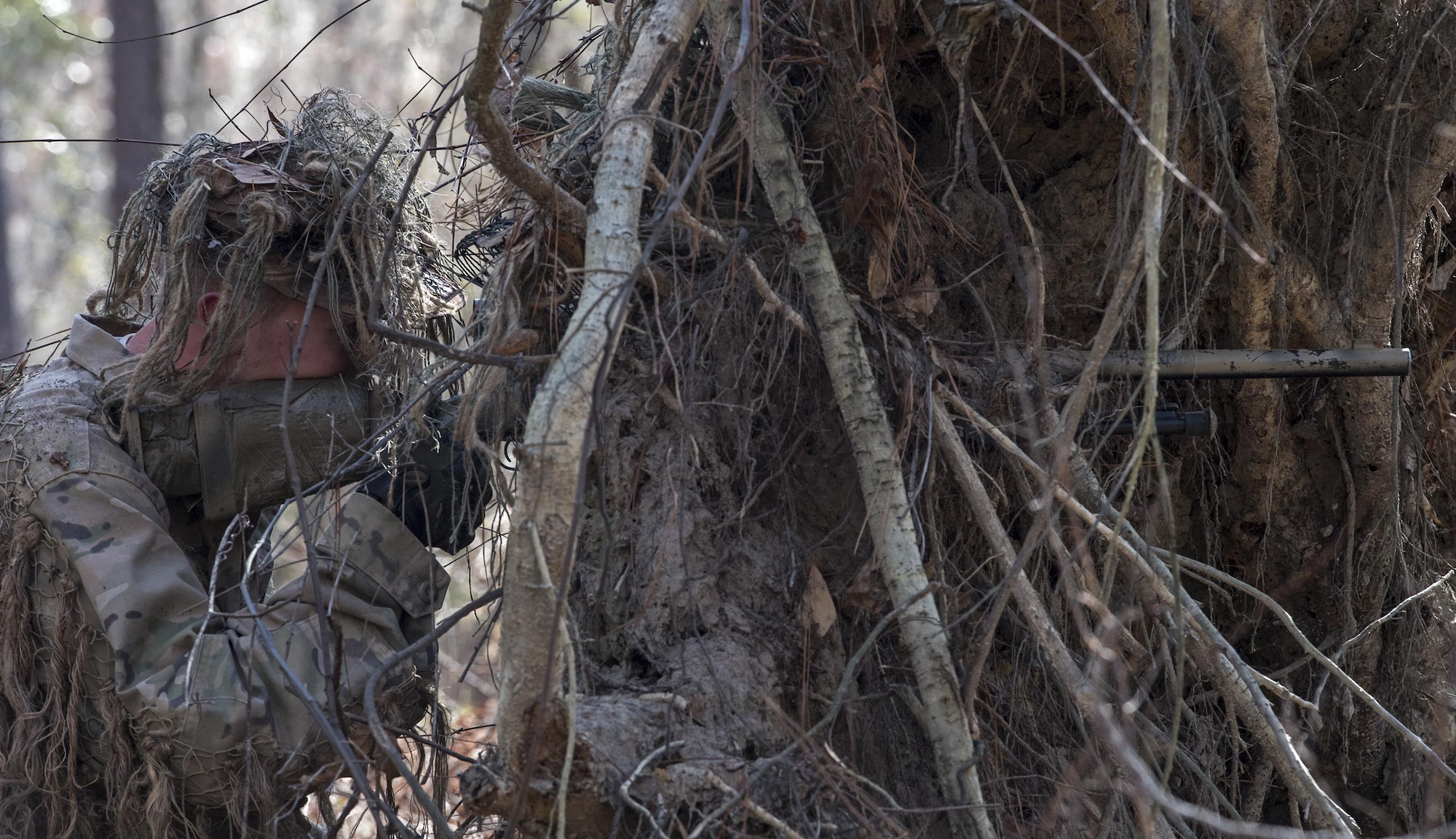 Senior Airman James Kendrick, 822d Base Defense Squadron close precision engagement team member, aims at a target during sniper training, Feb. 1, 2017, at Moody Air Force Base, Ga. Kendrick used the roots of a fallen tree to conceal his and his spotter’s position. (U.S. Air Force photo by Airman 1st Class Janiqua P. Robinson)
