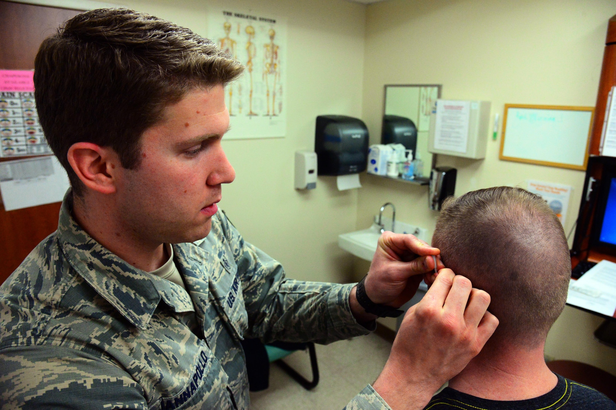 Staff Sgt. Dominic Iannapollo, 341st Medial Operations Squadron personnel reliability assurance program clinic technician, performs an acupuncture session on a patient Jan. 30, 2017, at Malmstrom Air Force Base, Mont. Acupuncture has become a popular method of treatment for personnel reliability program compliant Airmen because no additional medication is required which means there is less risk patients to experience negative side effects. (U.S. Air Force photo/Airman 1st Class Magen M. Reeves)