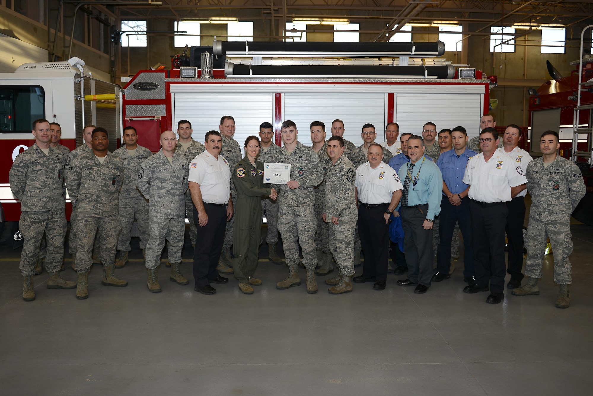 Airman 1st Class James Nicholson III, 47th Civil Engineer Squadron fire protection apprentice (front center), accepts the “XLer of the Week” award from Col. Michelle Pryor, 47th Flying Training Wing vice commander (front left), and Chief Master Sgt. George Richey, 47th FTW command chief (front right), on Laughlin Air Force Base, Texas, Jan. 25, 2017. The XLer is a weekly award chosen by wing leadership and is presented to those who consistently make outstanding contributions to their unit and Laughlin. (U.S. Air Force photo/Airman 1st Class Benjamin N. Valmoja)