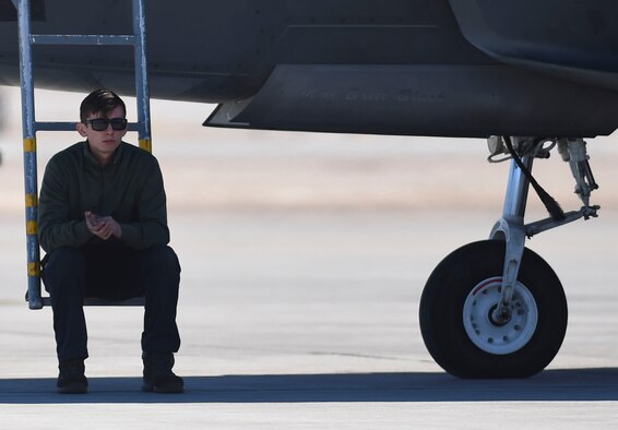U.S. Air Force Airman 1st Class Brian Dowling, 27th Aircraft Maintenance Unit crew chief, takes a break while waiting for an F-22 Raptor pilot to arrive to his jet during Red Flag 17-1 at Nellis Air Force Base, Nev., Jan. 26, 2017. Crew chiefs conduct preflight checks before pilots arrive to ensure that all aircraft maintenance safety measures are in standards. (U.S. Air Force photo by Staff Sgt. Natasha Stannard)