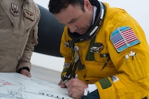 Maj. Ryan, a U-2 pilot, signs a mural created in celebration of a U-2 airframe achieving a 30,000 flight hours at an undisclosed location in Southwest Asia, Feb. 2, 2017. This marked the second U-2 in the USAF fleet to reach the milestone and the first overall while flying expeditionary missions under Air Force Central Command. (U.S. Air Force photo/Senior Airman Tyler Woodward)