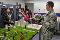 Staff Sgt. William H. Chapmon, 374th Operations Support Squadron Aircrew Flight Equipment Flight NCO in charge of chemical defense, explains how to operate night vision goggles to spouses as part of a Spouse Orientation Flight Feb. 1, 2017, at Yokota Air Base, Japan. The event included a static display of a C-130H Hercules engine, prop and aircraft, a C-12 Huron and a hands on night vision goggle demonstration. (U.S. Air Force photo by Airman 1st Class Donald Hudson)