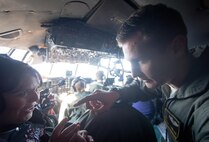 C-130H Hercules aircrew instructs a spouse on how to use a headset during a Spouse Orientation Flight Feb. 1, 2017, at Yokota Air Base, Japan. The event is the last scheduled C-130H Spouse Orientation Flight before the aircraft are retired from active duty. (U.S. Air Force photo by Airman 1st Class Donald Hudson)