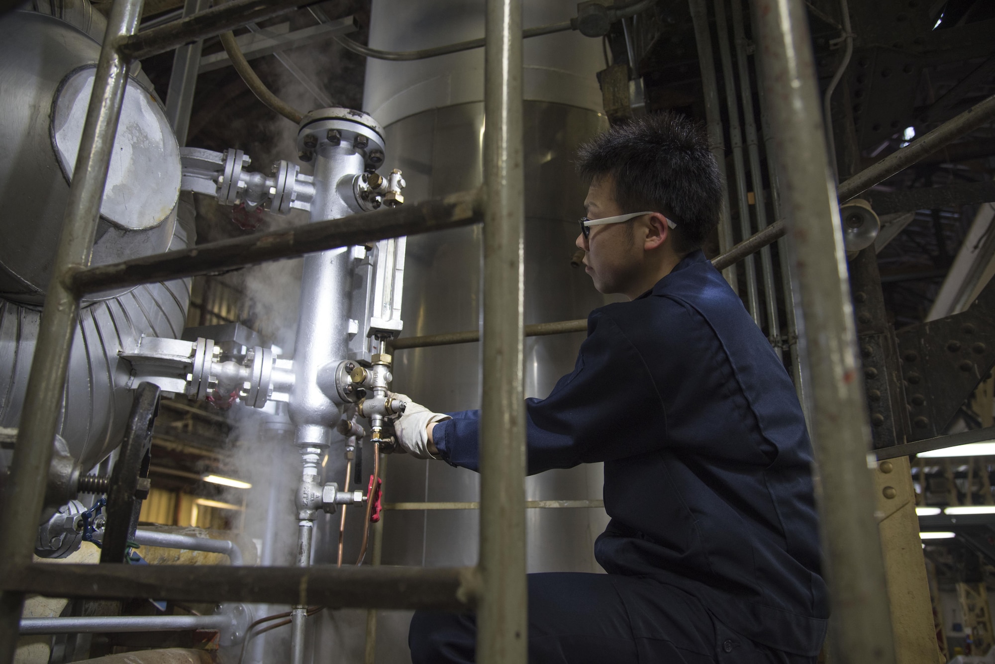 Shingo Matsumura, a 35th Civil Engineer Squadron boiler operator, releases steam from a boiler at Misawa Air Base, Japan, Jan. 30, 2017. As steam comes through a pressure gauge it allows technicians to check the pressure of the instrument, ensuring the conditions are not hazardous. The operators use the inspection for analyzing the cleanliness of the boilers. (U.S. Air Force photo by Airman 1st Class Sadie Colbert)
