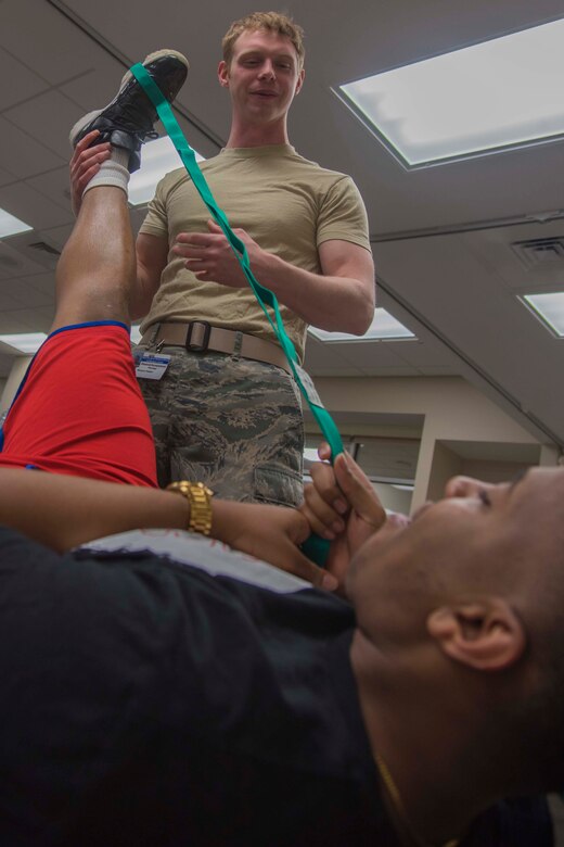 Staff Sgt. Kivynn Pabst, 779th Medical Group physical medicine technician, assists U.S. Navy Petty Officer 3rd Class Jovoni Vazquez, Malcolm Grow Medical Center patient, with a stretch during a physical therapy session at Joint Base Andrews, Md., Feb. 2, 2017. Pabst utilized techniques to help Vazquez recover from a leg injury. (U.S. Air Force photo by Airman 1st Class Valentina Lopez)