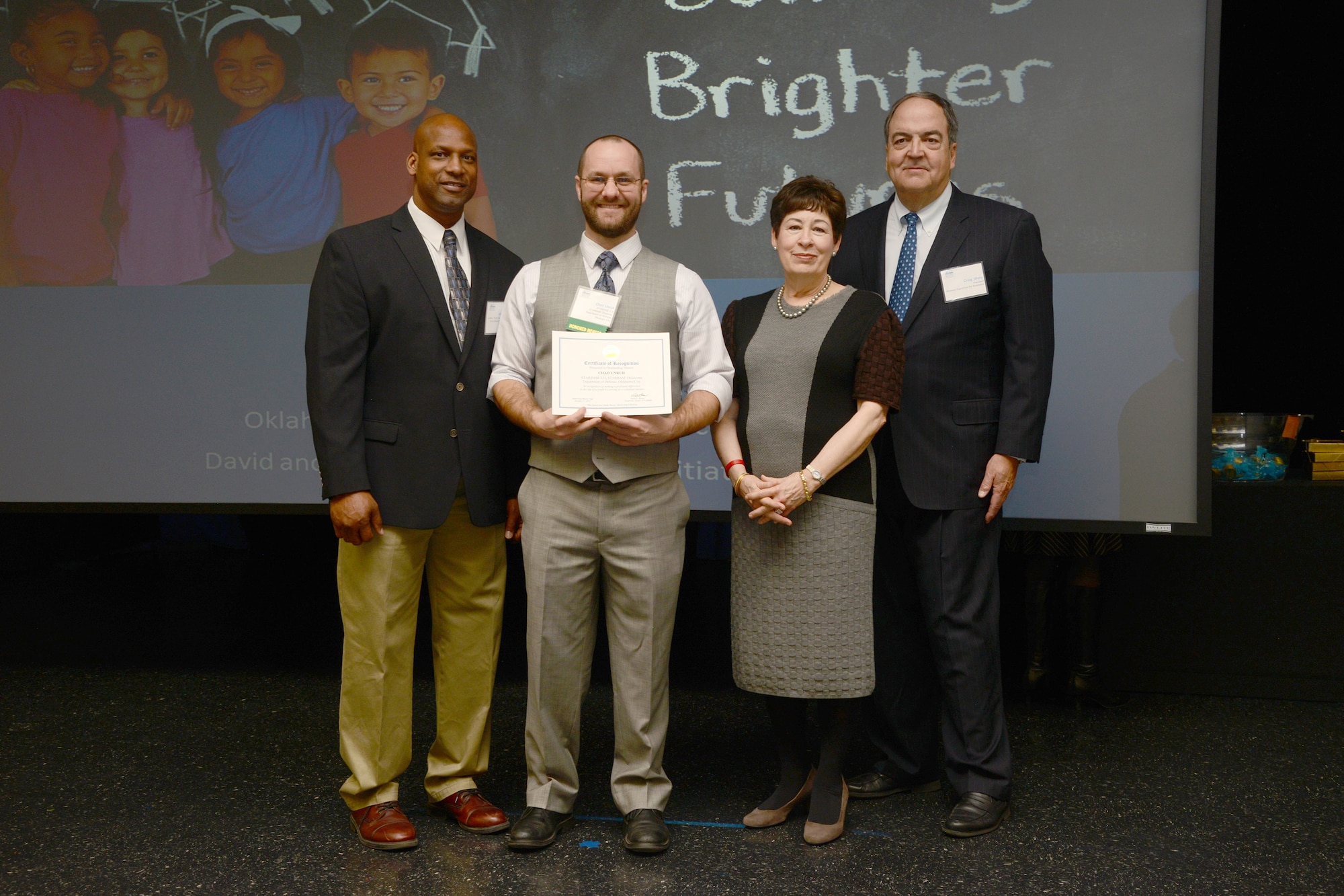 Chad Unruh, second from left, was among approximately 60 mentors honored during the Oklahoma Foundation for Excellence and Boren Mentoring Initiative’s Oklahoma Mentor Day at the University of Central Oklahoma Jan. 17. Mr. Unruh, an engineer with the 555th Support Maintenance Squadron, has been a vital asset to the STARBASE 2.0 after school programs at Tinker, providing his skills and support to the students. He was presented the award by, from left, Oklahoma author Alton Carter, Molly Boren and Craig Story with the Oklahoma Foundation for Excellence. (Air Force photo by Kelly White)