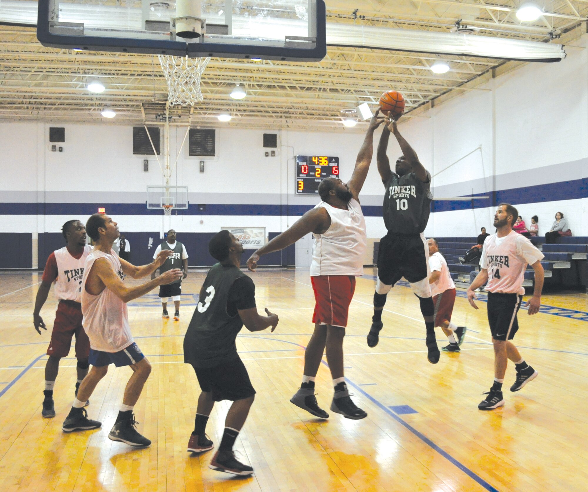 The 424th’s Andrae Primer leaps for a shot over the reach of Garbage’s 6-foot-11 center, Wade McGlashen. The teams with nearly identical records battled it out Jan. 25 at the Gerrity Center. McGlashen’s basket in the paint with 8 seconds left boosted Garbage over the top 42-41.  (Air Force photo by John Parker)