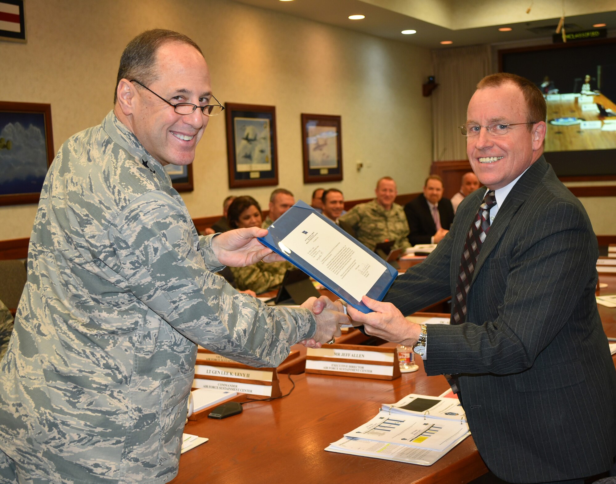 Lt. Gen. Lee K. Levy II, Air Force Sustainment Center commander, presents Jeffrey Allen, AFSC executive director, with a letter from Gen. Ellen Pawlikowski, Air Force Materiel Command commander, congratulating him on being a recipient of the 2016 Presidential Rank Award of Meritorious Executive. The award will be presented by the President of the United States in a formal ceremony later this year. (Air Force photo by Darren D. Heusel)