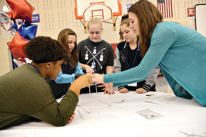 Mentor Kerri Yap helps her team construct a tower made of straws as part of team building exercises at the first STEM Girls Camp, “STEM Like a Girl”. (Air Force photo by Kelly White)