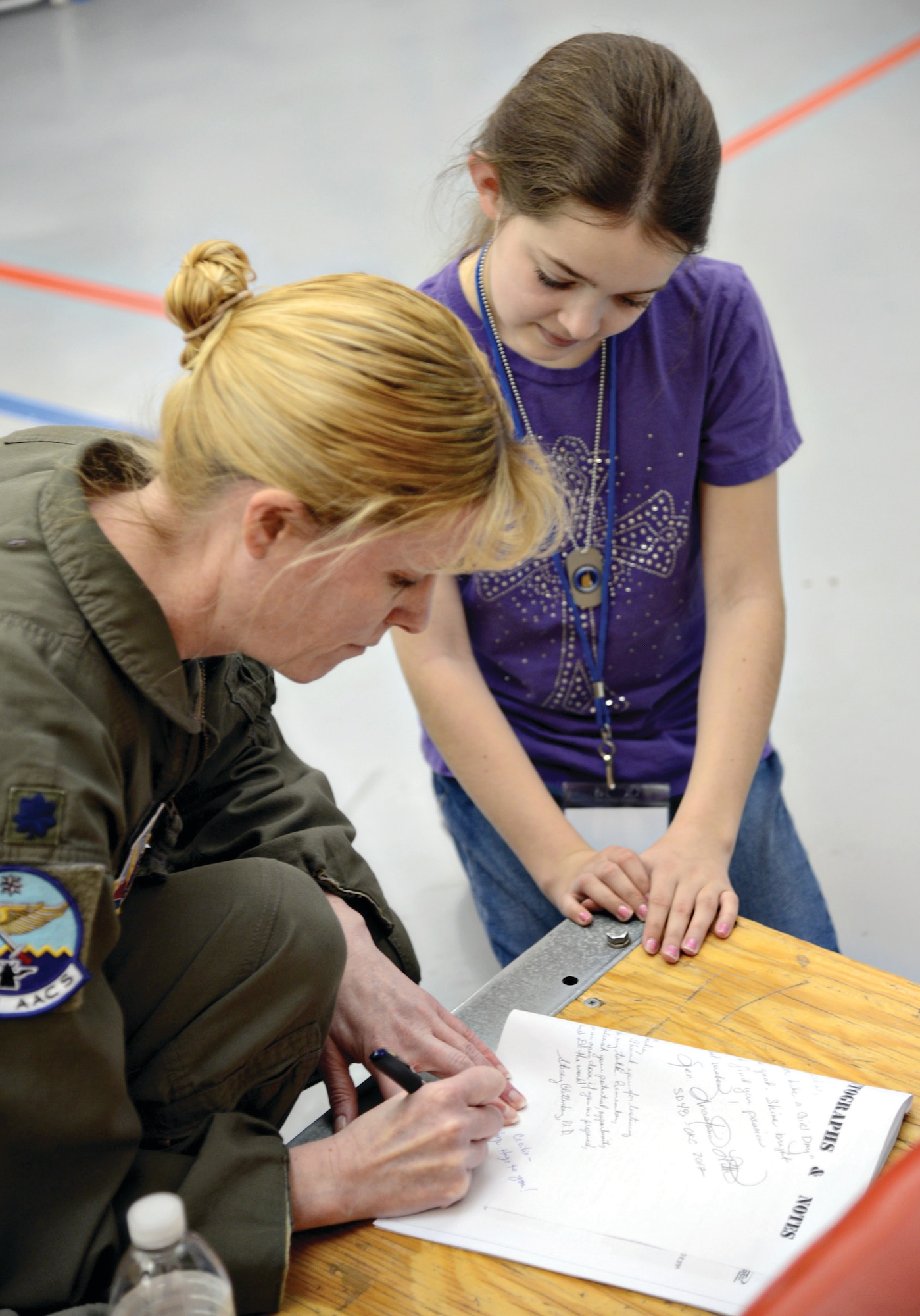 Lt. Col. Kristen Thompson, Commander, 960th Airborne Air Control Squadron, signs an autograph for a student attending Tinker’s first ever STEM Girls Camp, “STEM Like a Girl” Jan. 28. (Air Force photo by Kelly White)