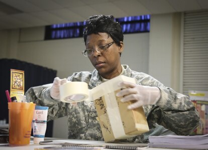 Sgt. 1st Class Lashara Simmons, a human resources noncommissioned officer and native of Newbern, North Carolina, currently assigned to the Joint Enabling Capabilities Command, 335th Signal Command (Theater) applies tape to seal a box in order to practice mailing procedures during a Unit Prevention Leader Course being taught at the 335th SC (T) Headquarters in East Point, Georgia Feb. 2.  (Official U.S. Army Reserve photo by Sgt. 1st Class Brent C. Powell)