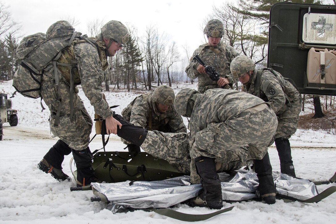 Army National Guard soldiers prepare to load a mock casualty onto an ambulance during a live-fire exercise at Camp Ethan Allen Training Site, Jericho, Vt., Jan. 26, 2017. Army National Guard photo by Spc. Avery Cunningham