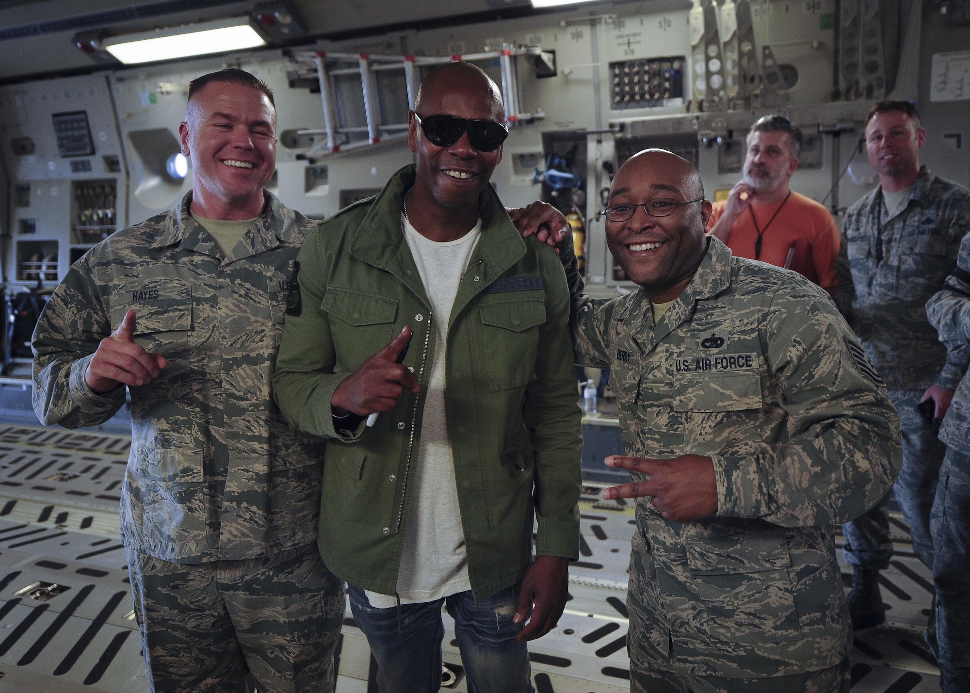 (from left)  Master Sgt. Mathew Hayes, 315th Aircraft Maintenance Squadron, Actor/comedian Dave Chappelle, and Tech Sgt. Philip Berry, 38th Aerial Port Squadron pose for a photo on a Joint Base Charleston, S.C. Feb. 2. Chappelle was in town for his stand-up comedy show when he made the visit to see service members and federal civilians at the base Feb. 2. (U.S. Air Force photo by Senior Airman Tom Brading)