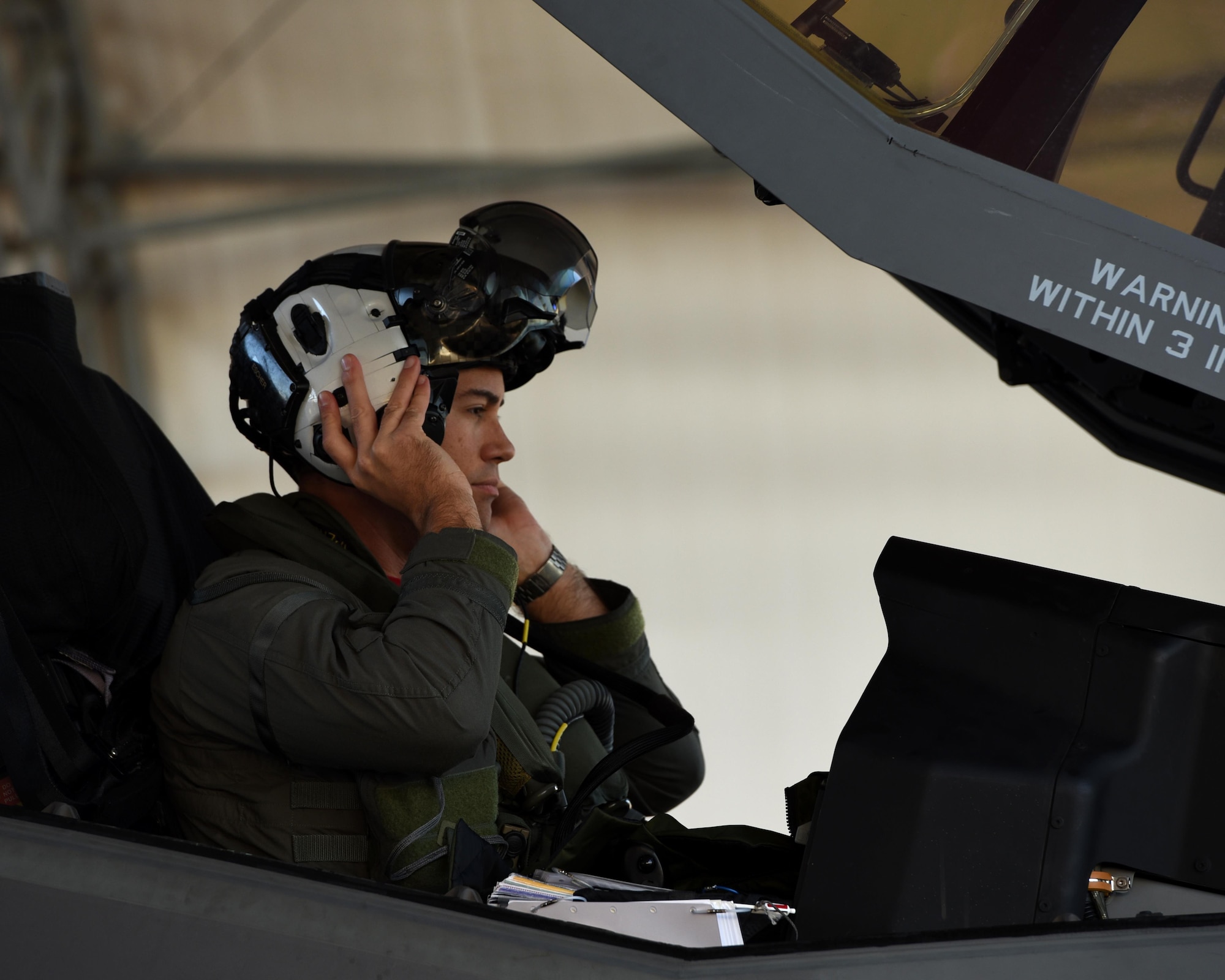 U.S. Navy Lt. Cmdr. Charles Escher, Strike Fighter Squadron (VFA-101) operations officer, dawns his helmet prior to flying an Air Force F-35A Dec. 6, 2016, at Eglin Air Force Base, Florida. For only the second time at Eglin AFB, a Naval Aviator has been selected to dual qualify in the U.S. Navy’s F-35C and the Air Force’s F-35A. Escher plans to use what he learns from his experience with the 33 FW to help the F-35 enterprise grow. He looks to join a group of test pilots at Edwards AFB, California, where he will have the opportunity to be the Navy’s voice for the aircraft weapons and vehicle system development. (U.S. Air Force photo/ Staff Sgt. Peter Thompson)