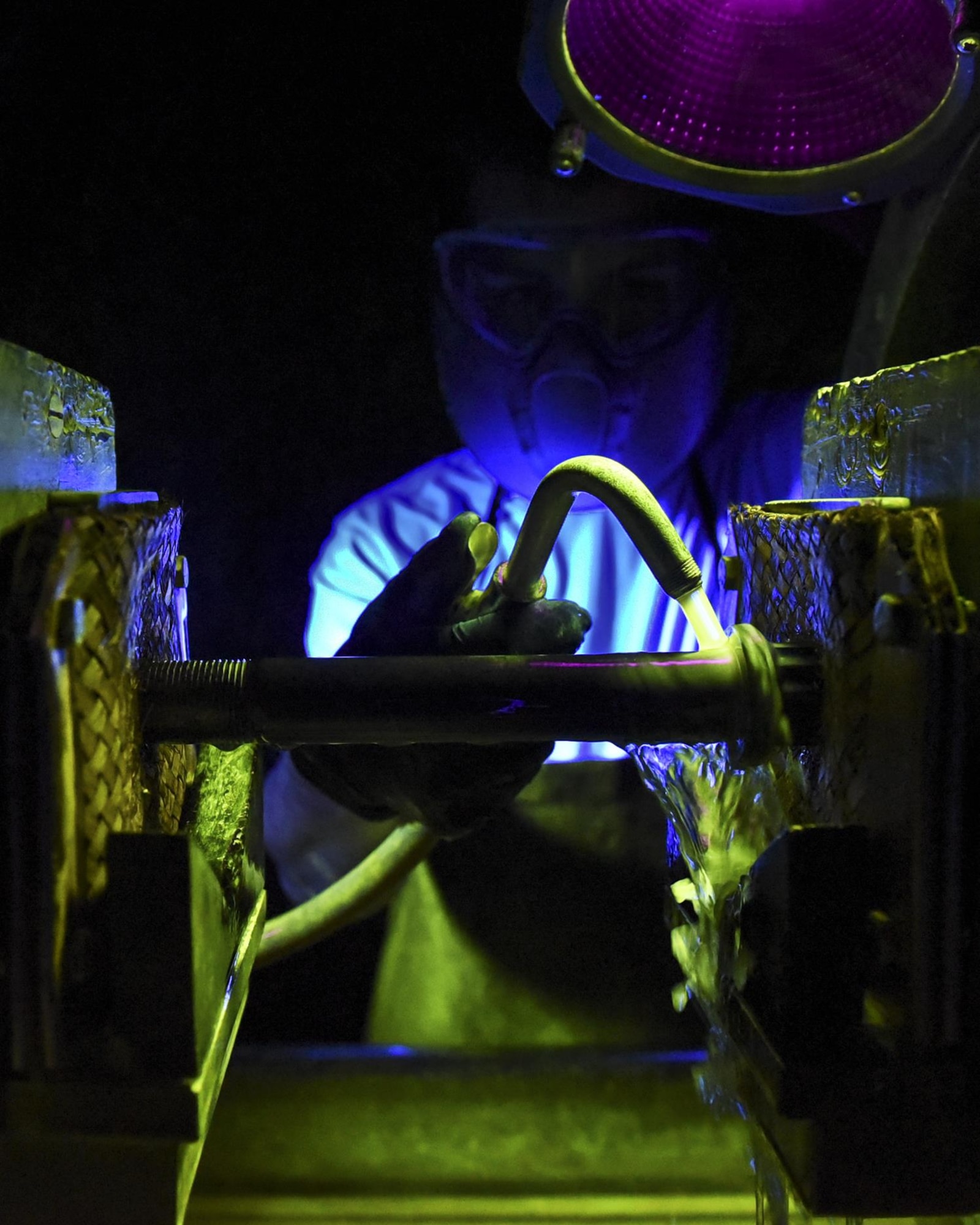 U.S. Air Force Airman 1st Class James Schwein, 19th Maintenance Squadron nondestructive inspections journeyman, covers a wheel bolt for a C-130J in magnetic particle oil Jan. 31, 2017, at Little Rock Air Force Base, Ark. The magnetic particle oil sinks into the cracks of the bolt and illuminates them when placed under a black light. (U.S. Air Force photo by Airman 1st Class Kevin Sommer Giron)