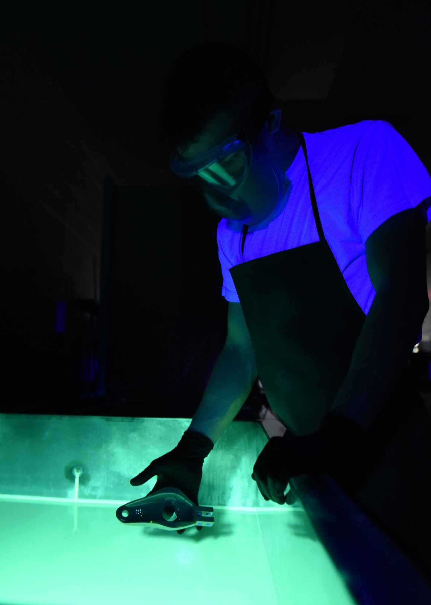 U.S. Air Force Airman 1st Class James Schwein, 19th Maintenance Squadron nondestructive inspections journeyman, submerges a C-130J tow fitting arm into liquid fluorescent penetrant Jan. 31, 2017, at Little Rock Air Force Base, Ark. The penetrant seeps into tiny openings in the part to identify potential cracks. (U.S. Air Force photo by Airman 1st Class Kevin Sommer Giron)