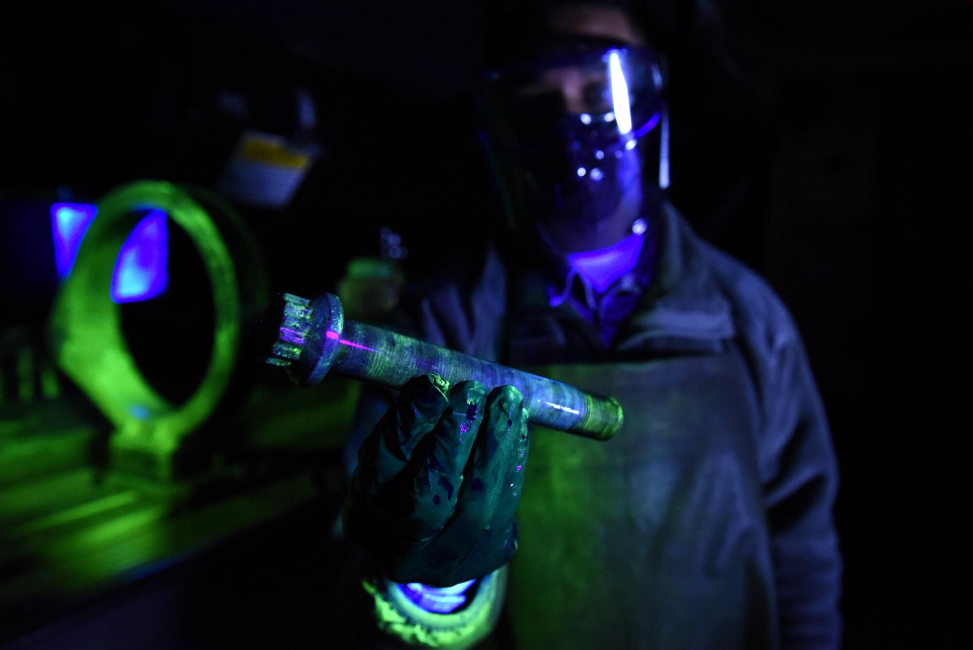 U.S. Air Force Airman 1st Class Brandon Davis, 19th Maintenance Squadron nondestructive inspections journeyman, holds an inspected main landing wheel bolt at Little Rock Air Force Base, Ark. NDI Airmen find small cracks in aircraft parts by running them through multiple chemical baths and using black lights to illuminate the defects. (U.S. Air Force photo by Airman 1st Class Kevin Sommer Giron)