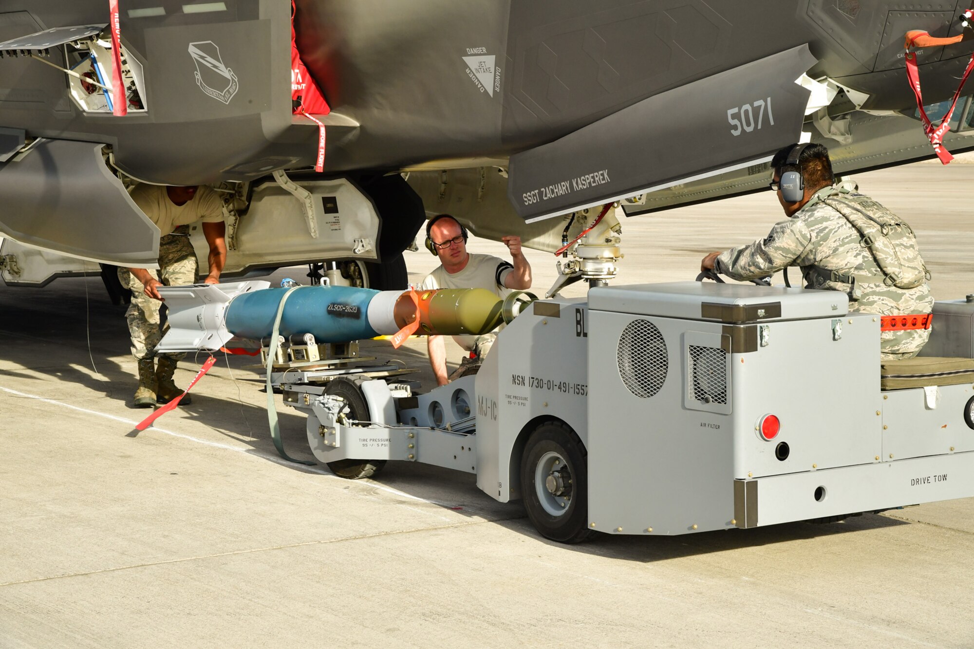 An Air Force weapons load crew assigned to the 34th Aircraft Maintenance Unit, Hill Air Froce Base, Utah, loads a GBU-12 into an F-35A Lightning II aircraft at Nellis AFB, Nevada, Feb. 1, 2017. (U.S. Air Force photo/R. Nial Bradshaw)