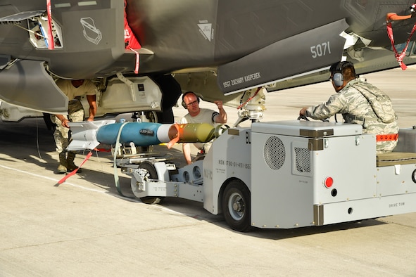 An Air Force weapons load crew assigned to the 34th Aircraft Maintenance Unit, Hill Air Froce Base, Utah, loads a GBU-12 into an F-35A Lightning II aircraft at Nellis AFB, Nevada, Feb. 1, 2017. (U.S. Air Force photo/R. Nial Bradshaw)