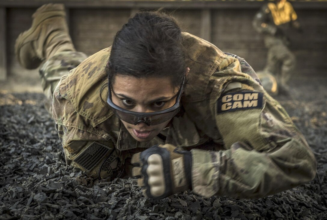 Air Force Capt. Natassia Cherne low crawls while navigating an obstacle course during Scorpion Lens at Fort Jackson, S.C., Jan. 29, 2017. Air Force combat camera personnel attend the annual training exercise. Cherne is a team lead assigned to the 1st Combat Camera Squadron. Air Force photo by Airman 1st Class James R. Crow