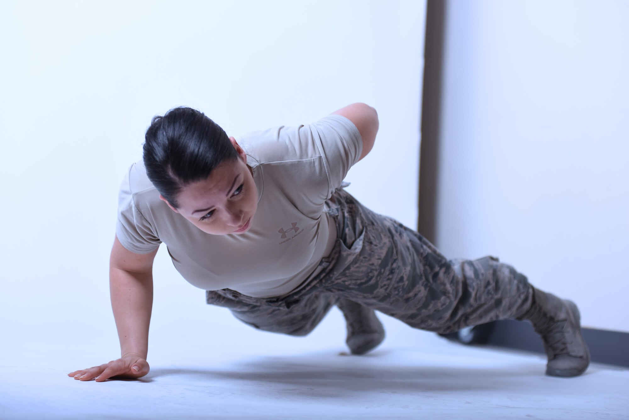 U.S. Air Force Second Lt. Briana Gent, the distinguished visitor flight officer with the 379th Air Expeditionary Wing protocol office, preforms one arm pushups at Al Udeid Air Base, Qatar, Jan. 25, 2017. Gent continually builds strength in physical discipline and mental resiliency through setting and achieving fitness goals. (U.S. Air Force photo by Senior Airman Cynthia A. Innocenti)