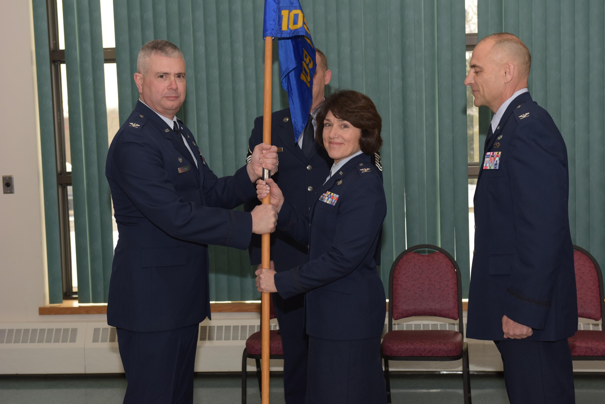 Col. Jeffrey Hedges (right), outgoing 109th Mission Support Group commander, looks on during  the MSG change of command ceremony. 109th Airlift Wing commander Col. Shawn Clotheir hands the guidon to the incoming MSG commander Col. Maureen Murphy during this time honored military tradition signifying the transfer of responsiblity. The ceremony took place at Stratton Air National Guard Base, New York, on Feb. 4, 2017. (U.S. Air National Guard photo by Staff Sgt. Ben German/Released)