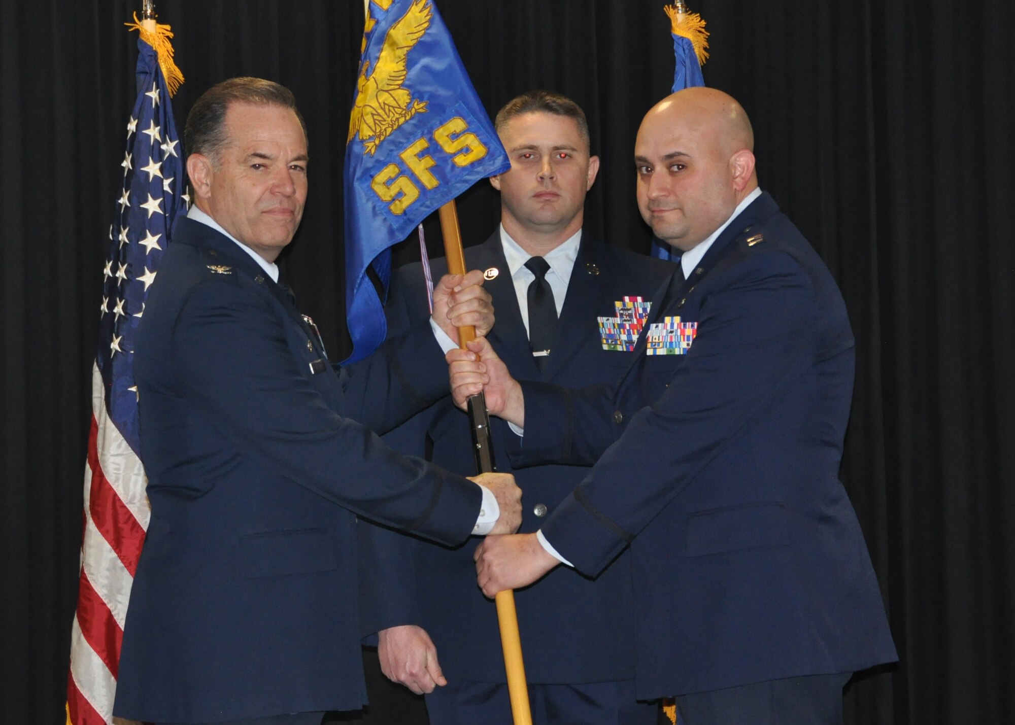 Col. Mark S. Larson, left,  931st Air Refueling Wing commander, passes the 931st Security Forces Squadron guidon to Capt. Phillip B. Werner, incoming 931 SFS commander, during an assumption of command ceremony Feb. 4, 2016, McConnell Air Force Base, Kan. The passing of the guidon symbolizes the transfer of authority from one commander to the next. (U.S. Air Force photo by Senior Airman Preston Webb)