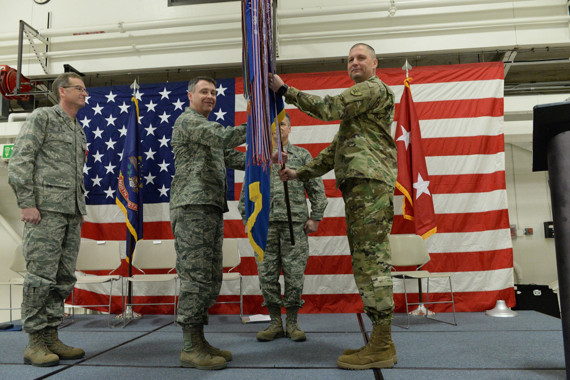 Maj. Gen. Al Dohrmann, the North Dakota adjutant general, right, presents the 119th Wing unit flag to Col. Thomas “Britt” Hatley in a symbolic gesture with the flag representing the organizational command of the 119th Wing at the North Dakota Air National Guard Base, Fargo, N.D., Feb. 4, 2017. (U.S. Air National Guard photo by Senior Master Sgt. David H. Lipp/Released)