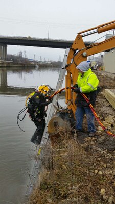 Dive Supervisor Shanon Chader assists Diver Steve England to exit the water.