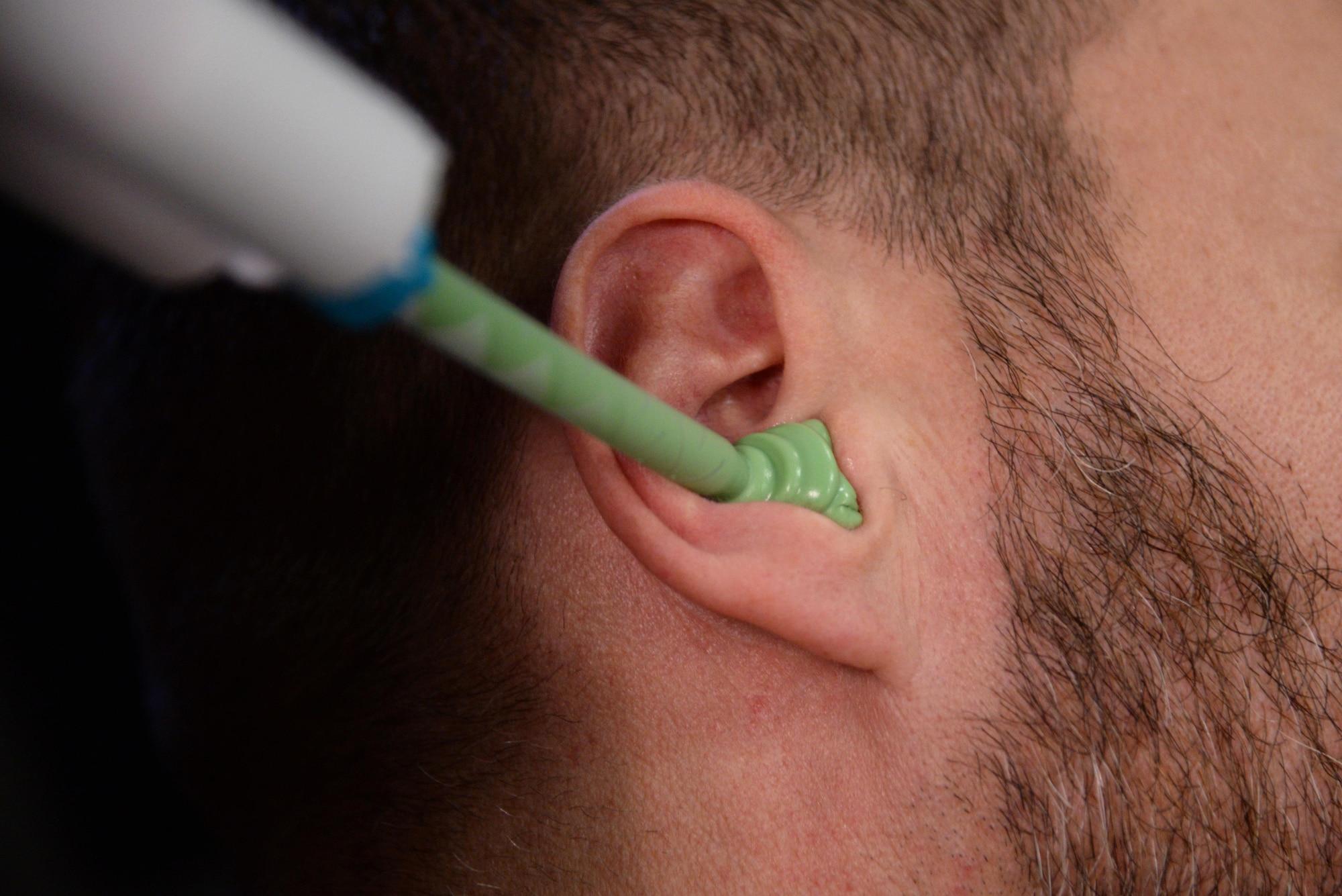 Molding material is applied to the ear of an Air Force Office of Special Investigations agent at an OSI office at Ramstein Air Base, Germany, Jan. 6, 2017. Approximately $20,000 was saved by deciding to not use an outside contractor with this effort. (U.S. Air Force photo by Airman 1st Class D. Blake Browning)
