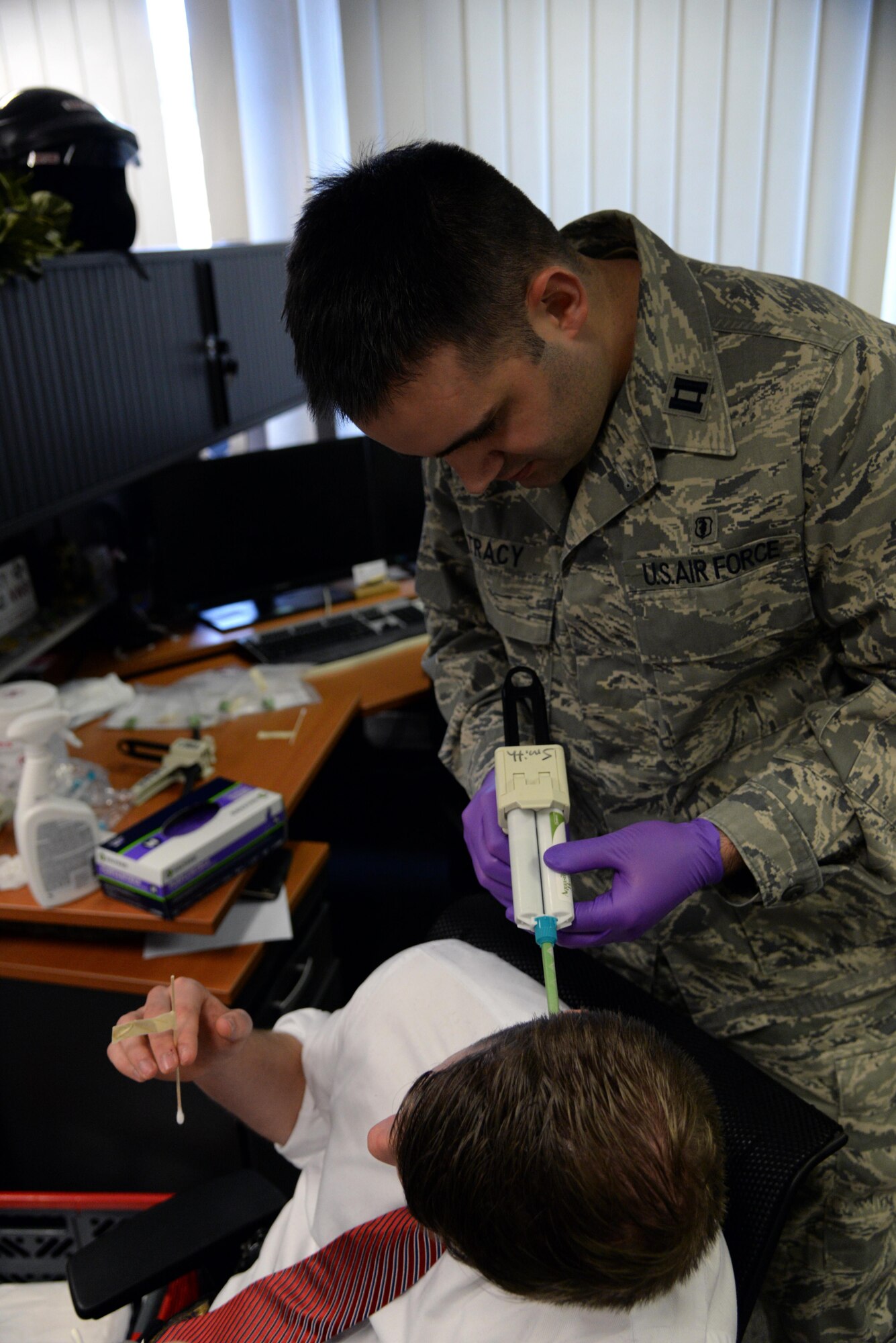 Capt. Christopher Tracy, 86th Dental Squadron dentist, applies molding material to the ear of an Air Force Office of Special Investigations agent at an OSI office at Ramstein Air Base, Germany, Jan. 6, 2017. Each mold took 10 to 15 minutes to become firm enough to remove. (U.S. Air Force photo by Airman 1st Class D. Blake Browning)