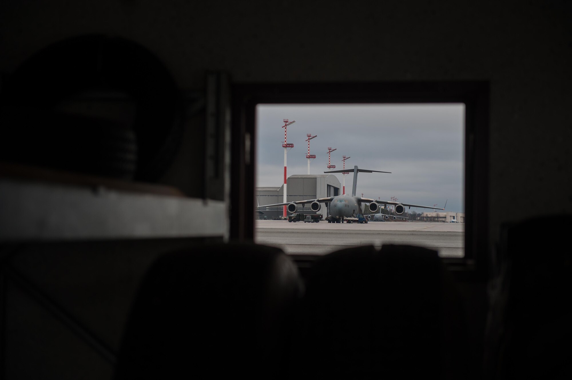 A C-17 Globemaster III is seen taxiing on the flightline from within an equipment warehouse belonging to the 86th Vehicle Readiness Squadron’s special vehicle maintenance shop on Ramstein Air Base, Germany, Jan. 30, 2017. Special vehicle maintainers keep flightline vehicles running smoothly so units can transport items around base and to or from planes. (U.S. Air Force photo by Airman 1st Class Lane T. Plummer)