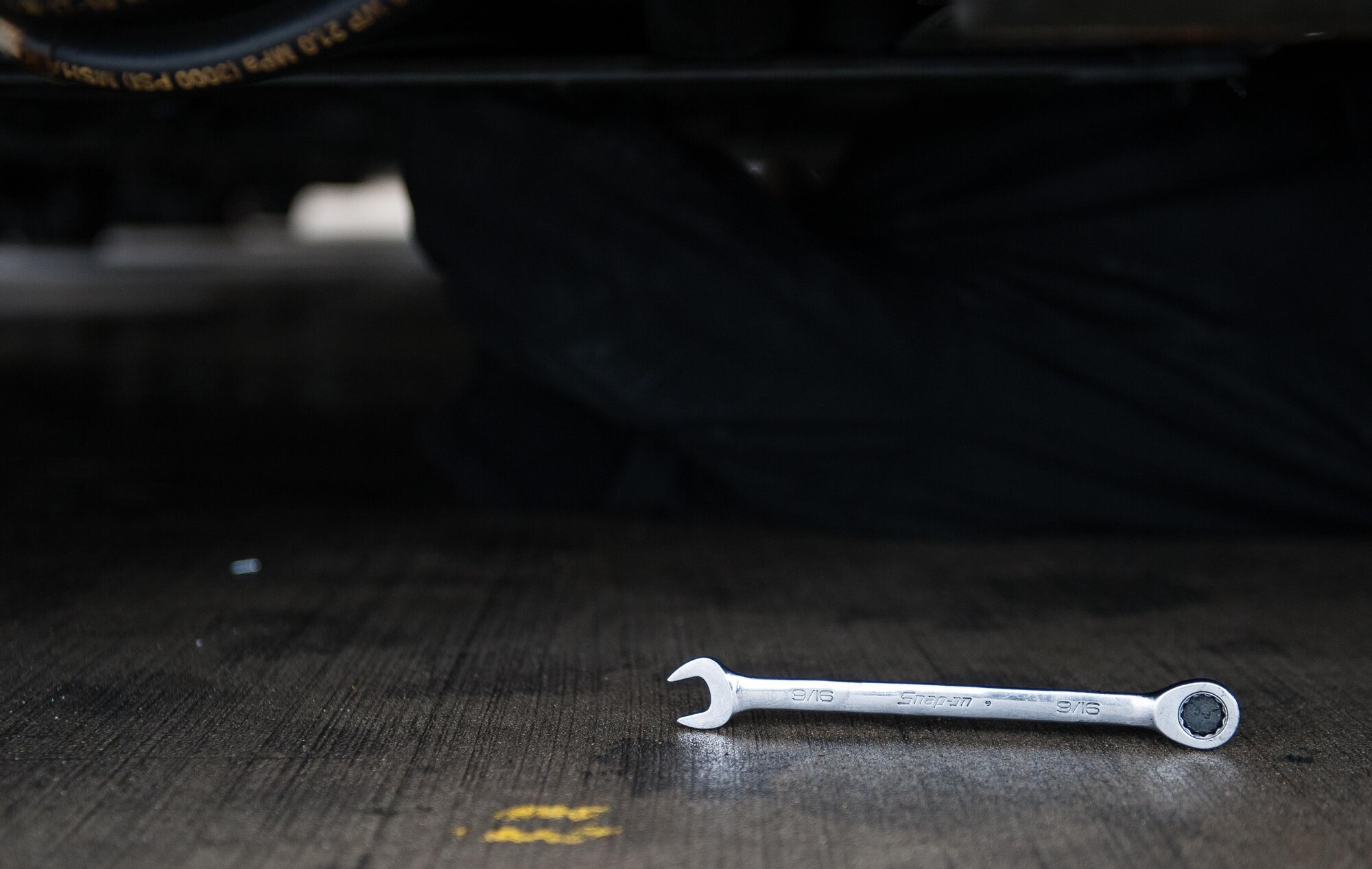 A wrench lays on the flightline on Ramstein Air Base, Germany, Jan. 30, 2017. Airmen were tasked with replacing a faulty starter on a Tunner 60K Loader. With a powered conveyor system and a height-adjustable deck, the Tunner Aircraft Cargo Loader gets cargo onto aircraft. (U.S. Air Force photo by Airman 1st Class Lane T. Plummer)