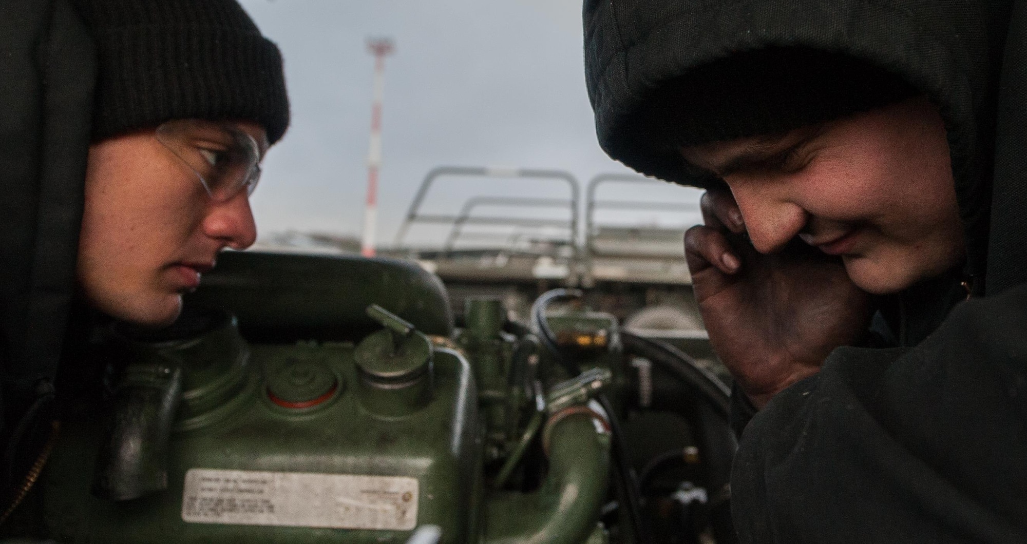 Airmen 1st Class Brennan Gregory, left, and Dakota Staten, 86th Vehicle Readiness Squadron special vehicle maintenance journeymen, communicate with their shop after they removed a vehicle’s stuck exhaust manifold to gain access to a faulty starter on Ramstein Air Base, Germany, Jan. 30, 2017. From 7 a.m. to 4 p.m., these Airmen spend their day doing the greasy work that keeps vehicles ready for any mission. (U.S. Air Force photo by Airman 1st Class Lane T. Plummer)