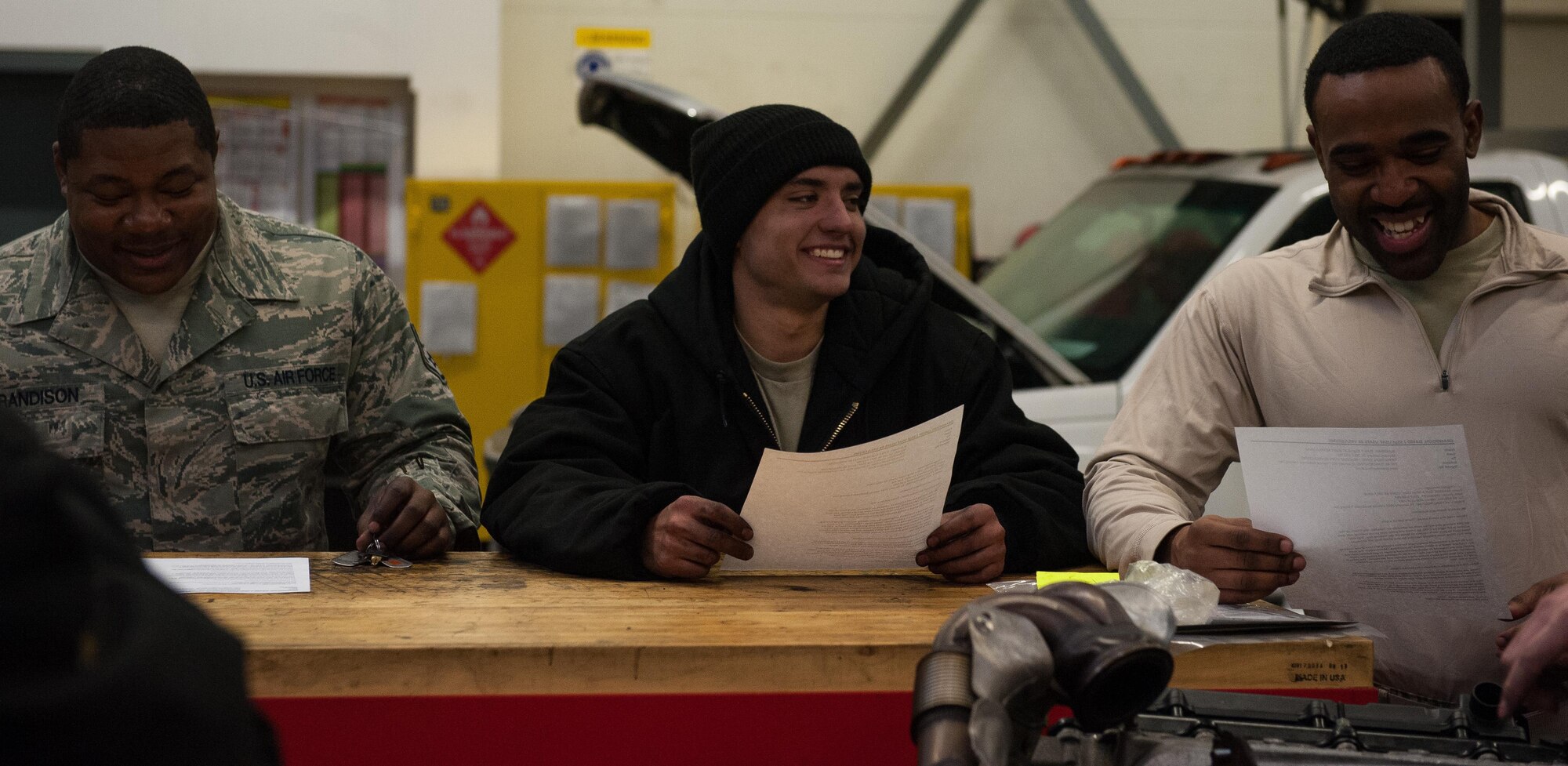 Airman 1st Class Brennan Gregory, center, 86th Vehicle Readiness Squadron special vehicle maintenance journeyman, discusses the day’s work with his coworkers during a shop meeting on Ramstein Air Base, Germany, Jan. 30, 2017. Gregory says his passion for the job comes from the people he works with. (U.S. Air Force photo by Airman 1st Class Lane T. Plummer)