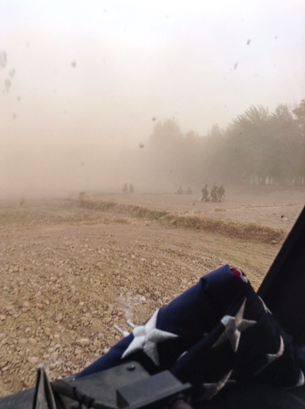 Green Berets of Special Forces Operational Detachment - Alpha 0224, 10th Special Forces Group (Airborne), and their Afghan partner force, transport wounded soldiers through a hot landing zone to a waiting medical evacuation helicopter while a determined enemy force continues to attack during the Battle of Boz Qandahari, Afghanistan on Nov. 3, 2016. The folded American flag, which was on the MEDEVAC helicopter that day, was later given to ODA 0224 in memory of two Green Berets who were killed in action during that all-night battle. (Courtesy photo)