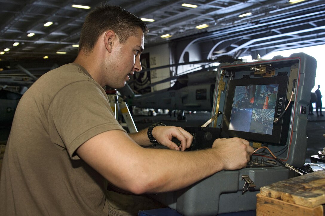 Navy Petty Officer 3rd Class David Rosas uses an operator control unit to steer a robot during a remote robot training exercise in the hangar bay aboard the aircraft carrier USS Carl Vinson in the Pacific Ocean, Feb. 1, 2017. Rosas is assigned to Explosive Ordnance Disposal Mobile Unit 3. Navy photo by Petty Officer 3rd Class Tom Tonthat