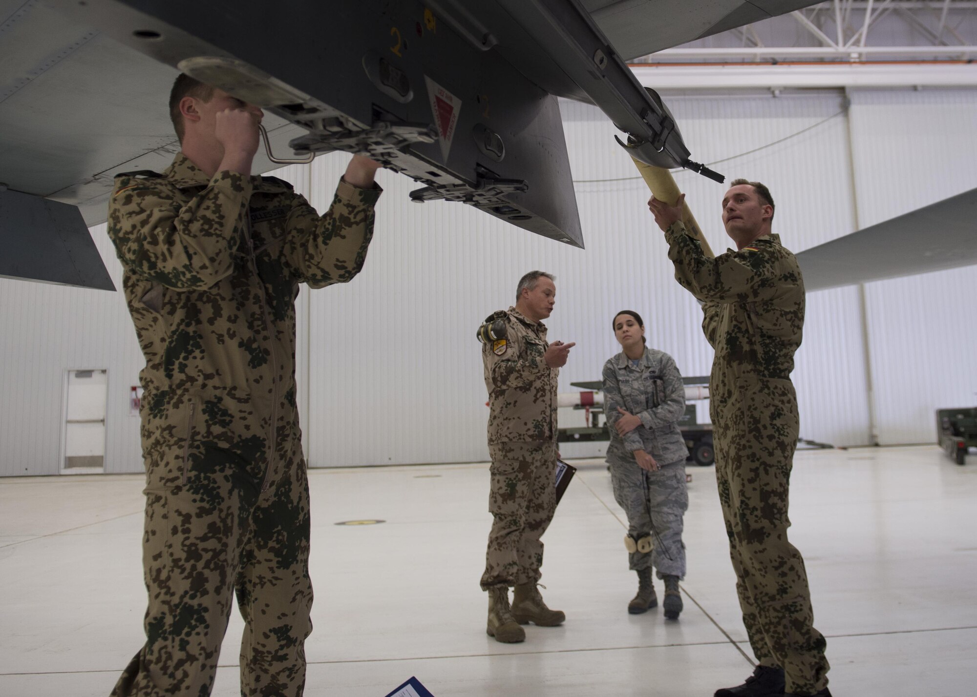 German Air Force Flying Training Center members load an inert missile onto a GAF Tornado during a quarterly load crew competition at Holloman Air Force Base, N.M., Jan. 20, 2016. The GAF competed for the last time in the load crew competition to have their skills evaluated alongside the MQ-9 Reaper, and the F-16 Fighting Falcon load crews. Points for the competition are awarded based on weapons loading, tool kit inspection and uniform inspection categories. (U.S. Air Force photo by Senior Airman Chase Cannon/ Released)